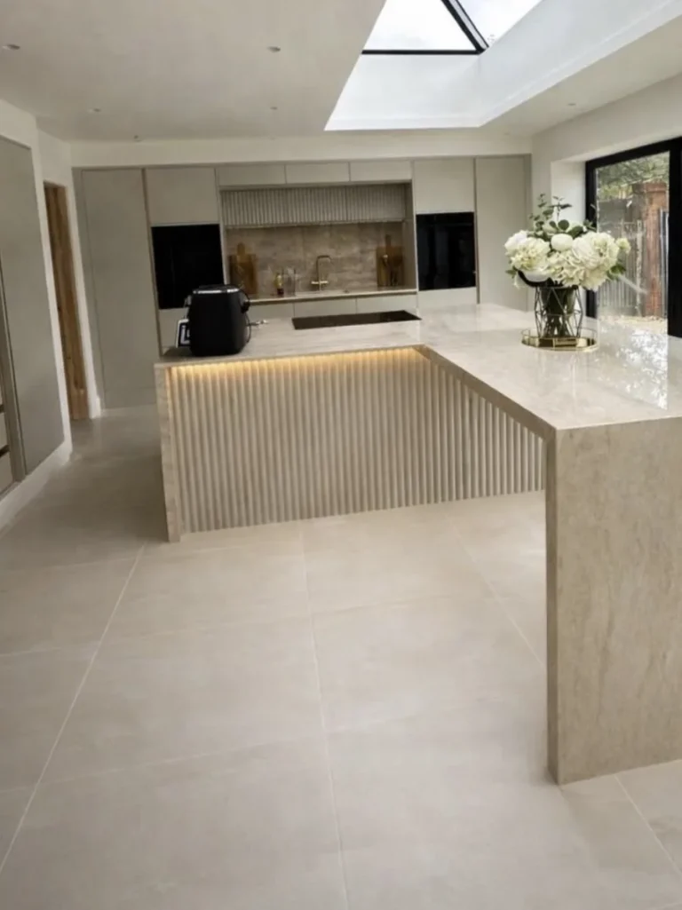 Contemporary kitchen tiling with fluted marble island, skylight and large format floor tiles