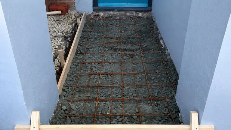 Front path base prepared with steel reinforcement mesh before porcelain tiles are installed.