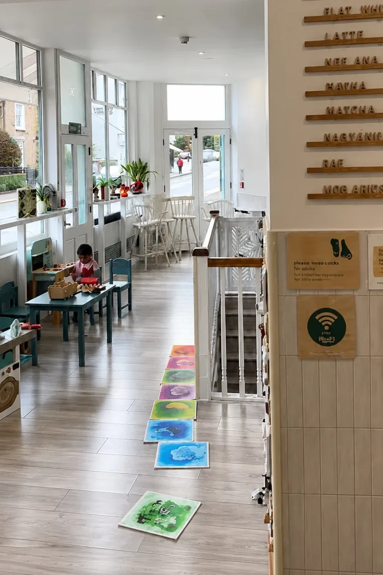 Commercial cafe and play-space interior with floor tiling, tiled wall detail and bright street-facing windows