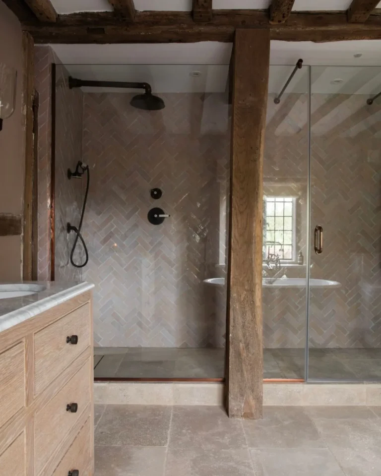 Period home bathroom with herringbone shower tiles, exposed timber beams and glass shower screen