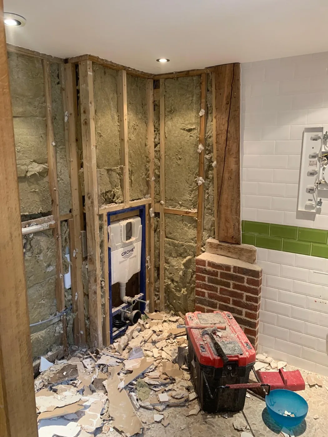 Surrey barn conversion bathroom before renovation with exposed timber frame, insulation and first-fix plumbing.